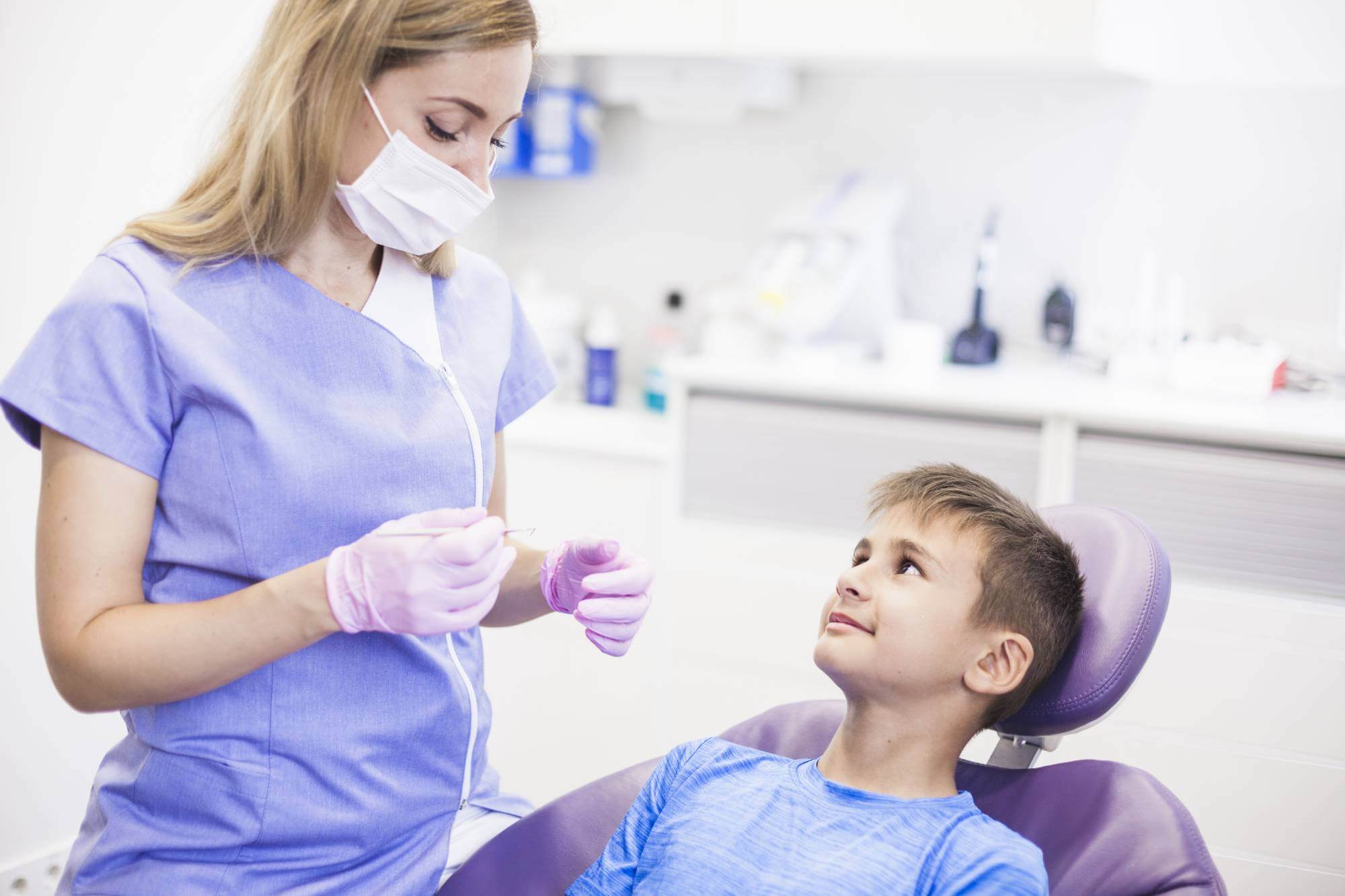 doctor with dental equiptment treatment a younger boy